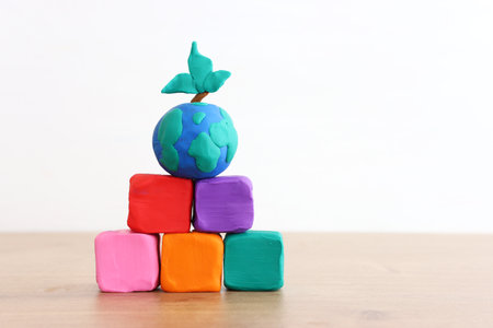 Concept image stack of colorful cubes and globe over wooden tableの写真素材