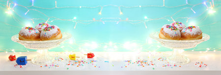 Image of jewish holiday Hanukkah of doughnut and wooden spinning tops with letters that mean, a great miracle happened hereの写真素材