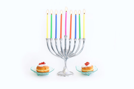Religion image of jewish holiday Hanukkah background with menorah (traditional candelabra), doughnut and candles over white backgroundの写真素材