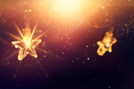 Christmas warm gold garland lights over dark background with glitter overlay