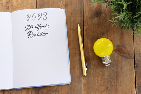 Business concept of top view 2023 new resolution list with notebook over wooden desk
