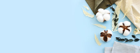Creative image of beautiful cotton flowers over blue background.