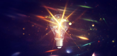 Light bulb over dark black background. Concept of creativity and innovation