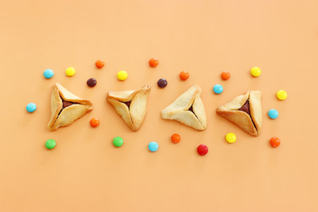 Purim celebration concept (jewish carnival holiday). Hamantaschen cookies over yellow background