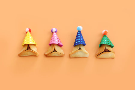 Purim celebration concept (jewish carnival holiday). Hamantaschen cookies over yellow background