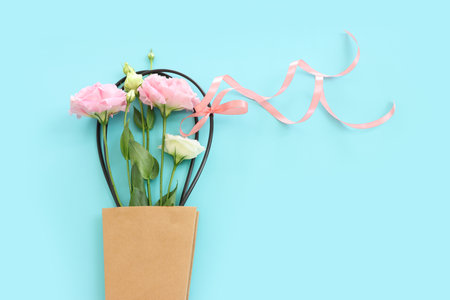Top view image of delicate lisianthus flowers over pastel blue backgroundの写真素材