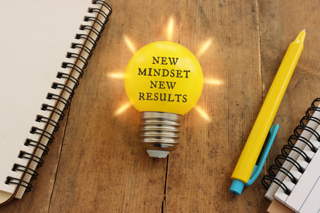 light bulb with the text new mindset in on wooden tableの写真素材