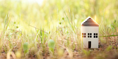 Concept image of a small house in nature. Idea of ecology, solar energy, and sustainabilityの写真素材