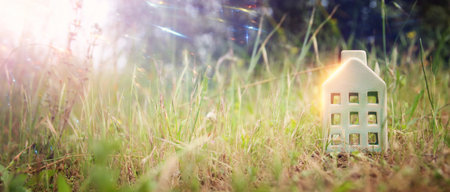 Concept image of a small house in nature. Idea of ecology, solar energy, and sustainabilityの写真素材