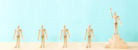 Concept image of a wooden figure progressing up a ladder to success and leadership