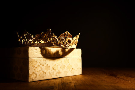 low key image of beautiful queen or king crown over wooden table. vintage filtered. fantasy medieval periodの写真素材