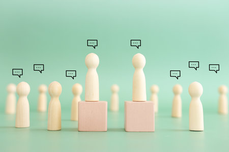 Wooden figures with speech bubbles. Concept of communication, information, and cooperationの写真素材