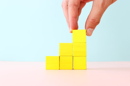 Wooden cubes as ladder or stairs over blue background