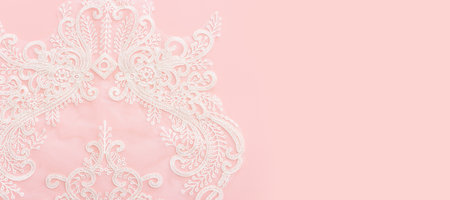 white delicate lace fabric over pink backgroundの写真素材