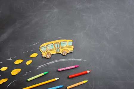 Back to school concept. bus and pencils over classroom blackboard. Top view
