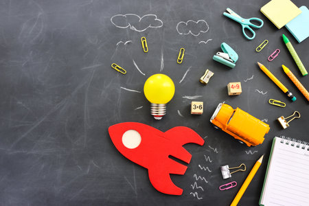 Back to school concept. rocket, bus and pencils over classroom blackboard. Top viewの写真素材