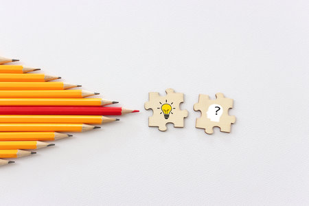 bright light bulb and question mark with pencils concept imageの写真素材
