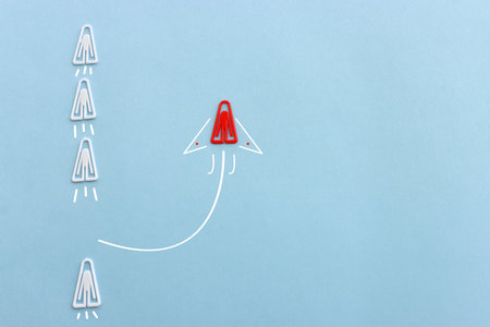 Concept image of unique thinking. Paper clips in the shape of airplane. Idea of teamwork and...