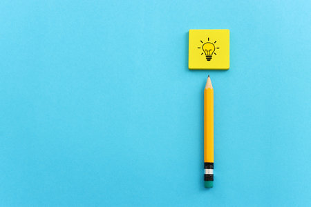 Education concept image. Pencil and light bulb metaphor over paper backgroundの写真素材