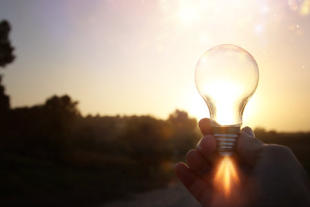 energy and business concept image. Creative idea and innovation. light bulb metaphor in front of the sunの写真素材
