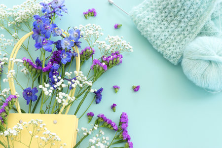 Beautiful spring flowers and cozy blue wool, knitting work