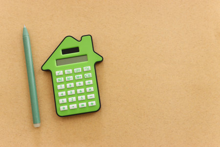 Top view image of green calculator in the shape of house. Concept of family budget and real estateの写真素材