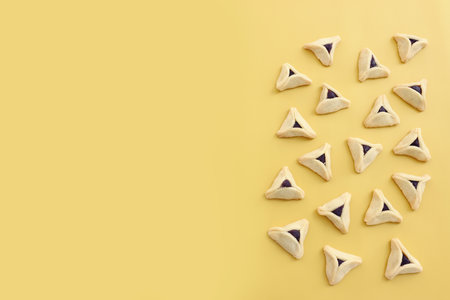 Purim celebration concept (jewish carnival holiday). Hamantaschen cookies over yellow backgroundの写真素材
