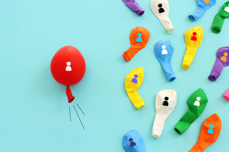 Red balloon leading the way ahead for the group. Concept of progress and developmentの写真素材