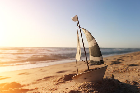 Small vintage boat on beach at summer sunsetの写真素材