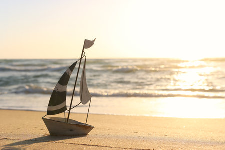 Small vintage boat on beach at summer sunsetの写真素材