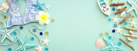 Top view of female swimsuit bikini, starfish, boat and monoi flower over pastel blue background....