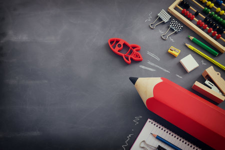 Back to school concept. rocket and pencils over classroom blackboard. Top viewの写真素材