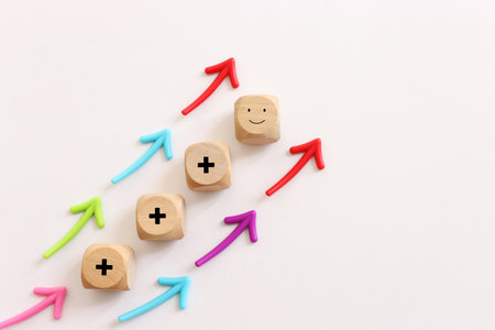 Concept image of satisfaction level. wooden cube with smiling face and arrows