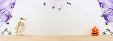 holidays image of Halloween. pumpkin and bird skeleton over wooden table