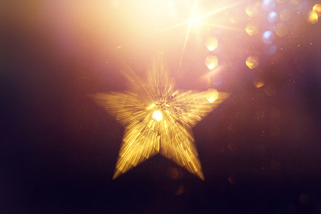 Christmas warm gold garland lights over dark background with glitter overlayの写真素材