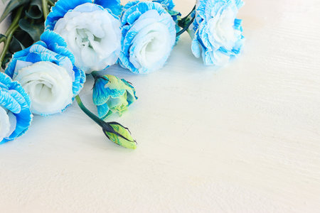 Top view image of blue flowers composition over wooden white background .Flat layの写真素材