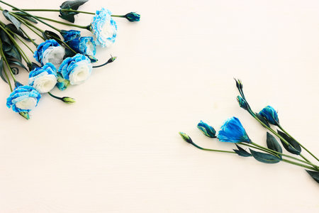 Top view image of blue flowers composition over wooden white background .Flat layの写真素材