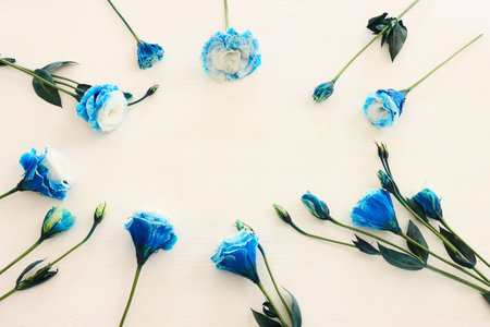 Top view image of blue flowers composition over wooden white background .Flat layの写真素材