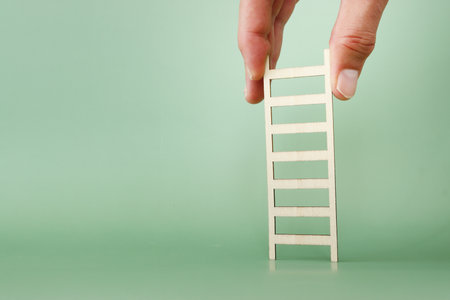 Hand holding ladder. Concept of aiming high and achieving successの写真素材