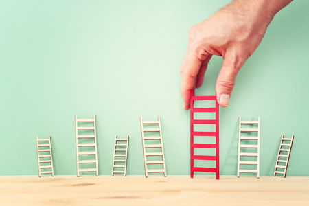 Hand holding ladder. Concept of aiming high and achieving successの写真素材
