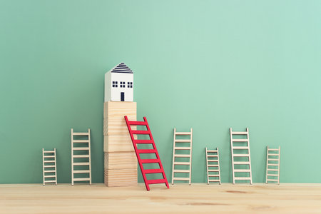 Small houses on wooden cubes and red ladder. Real estate and property value conceptの写真素材