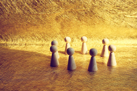 Wooden figures forming circle of teamwork. Concept of leadership, business, and challengeの写真素材
