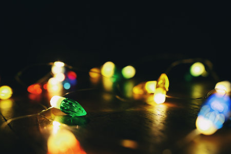 garland of bright Christmas lights on wooden tableの写真素材