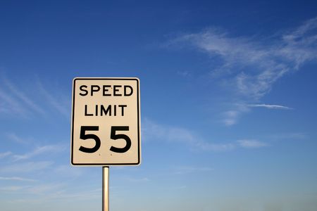 White sign with "speed limit 45" printed in black. Sign is shot against a blue sky with plenty of empty space for text, etc.の写真素材