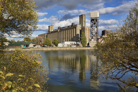 Grain elevator along the Buffalo, New York waterfront. The building, which was at one time the largest grain elevator in the world, is shot so it is framed by autumn-leaved trees.のeditorial素材