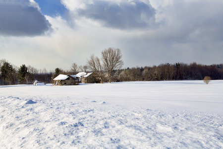 Snow covered, abandoned farm buildings in a wintery Western New York landscape.の写真素材