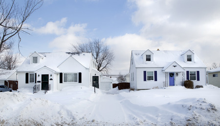 Two white suburban houses framed in white snow in Western New Yorkの写真素材