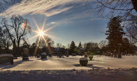 Wide angle view of snow covered graves in Buffalo's (New York) Forest Lawn Cemetery. Image is shot looking into the sun using only a UV filter.の写真素材