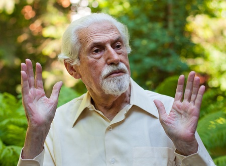 Elderly man making a facial expression of protest.