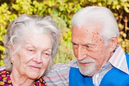 Portrait of an elderly couple sitting outdoors.の写真素材